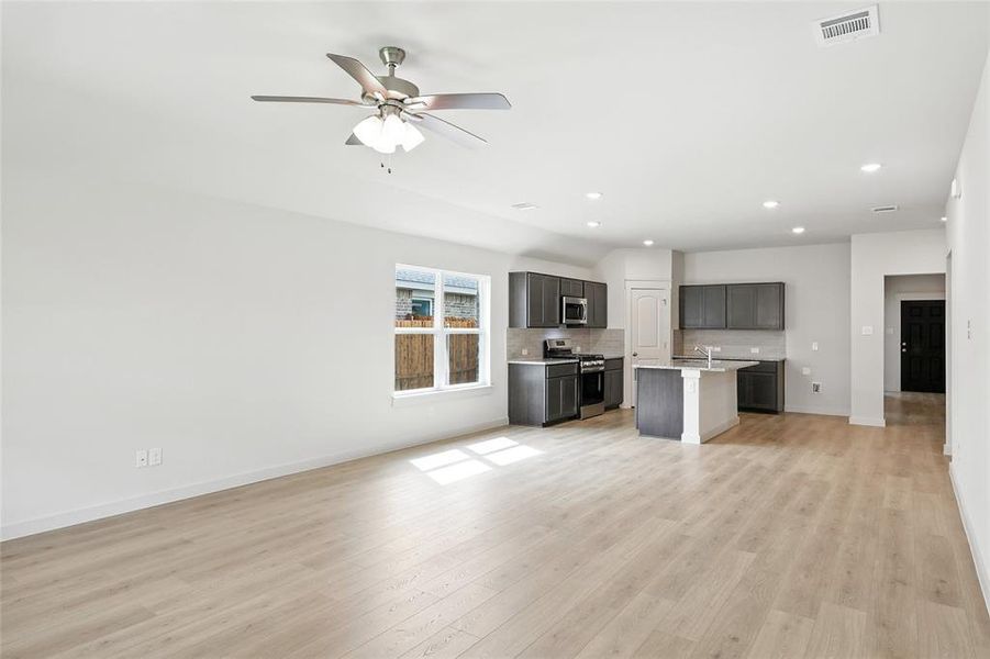 Unfurnished living room with light wood-type flooring, recessed lighting, and ceiling fan
