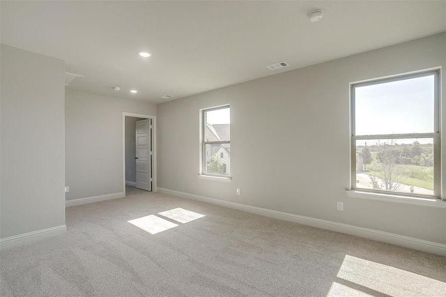 Unfurnished room featuring plenty of natural light, light carpet, and recessed lighting Unfurnished room featuring plenty of natural light, light carpet, and recessed lighting