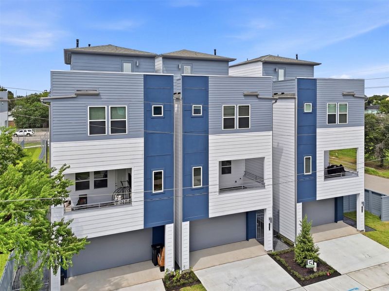 Modern three-story homes with sleek blue and white exteriors, featuring spacious balconies and attached garages.