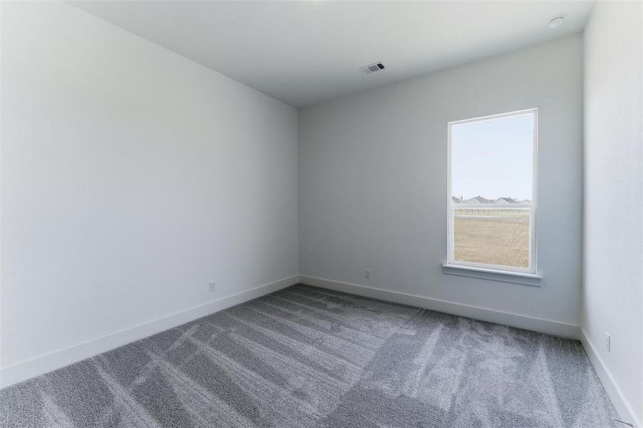 Carpeted spare room with baseboards