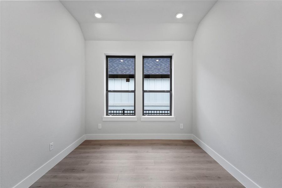 This handsome study/home office features laminate flooring, high sloped ceiling, recessed lighting, large windows, double doors, and custom paint!