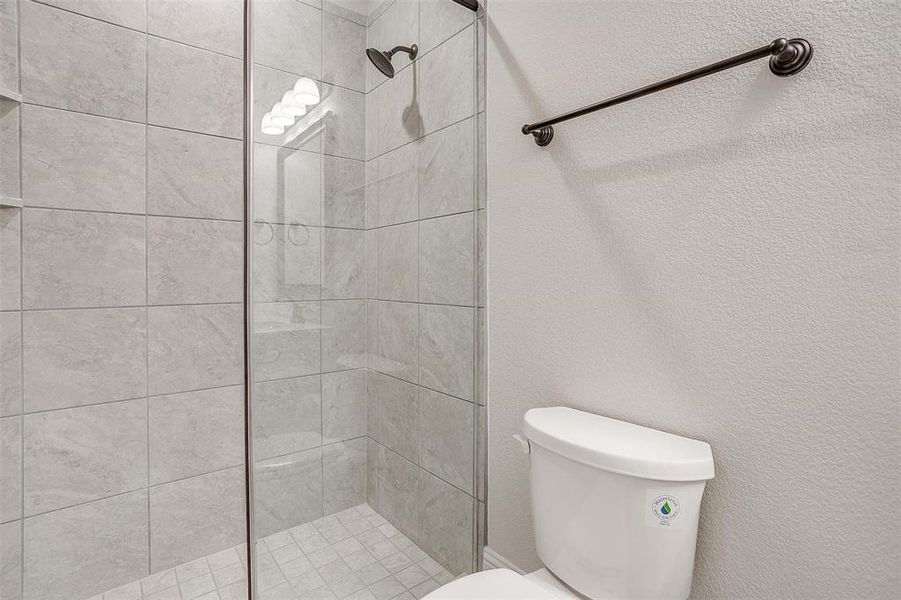 Bathroom featuring toilet and a tile shower