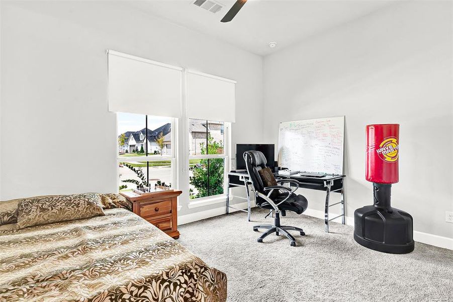 Bedroom featuring a desk, light colored carpet, and ceiling fan Bedroom featuring a desk, light colored carpet, and ceiling fan