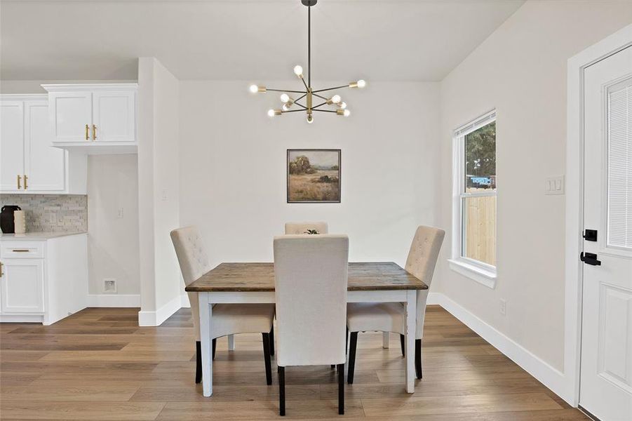 Dining area with light hardwood / wood-style flooring and a notable chandelier