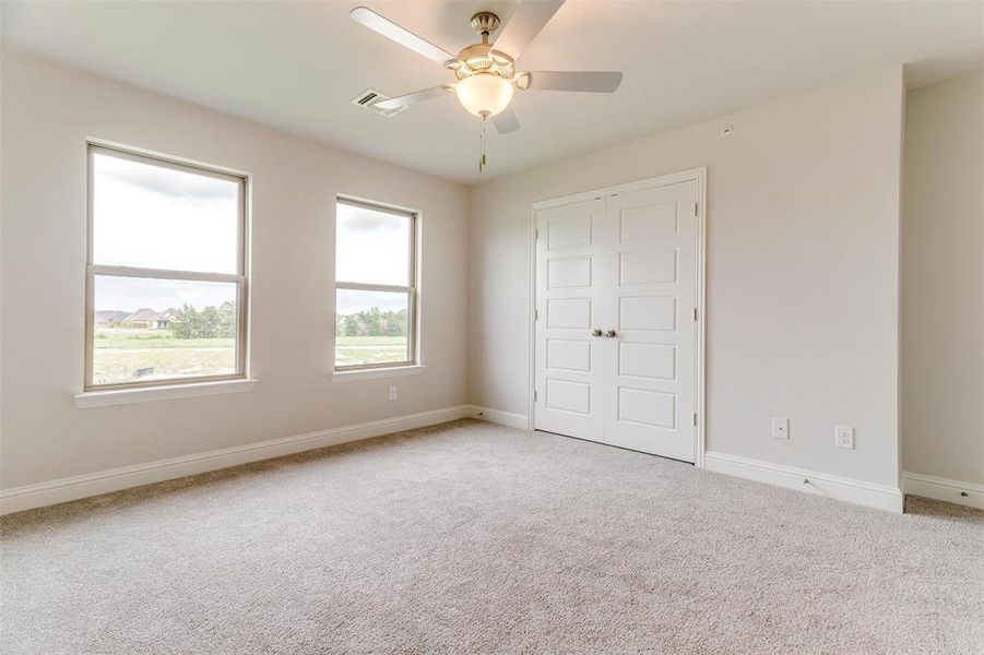 Unfurnished bedroom with a closet, ceiling fan, and carpet