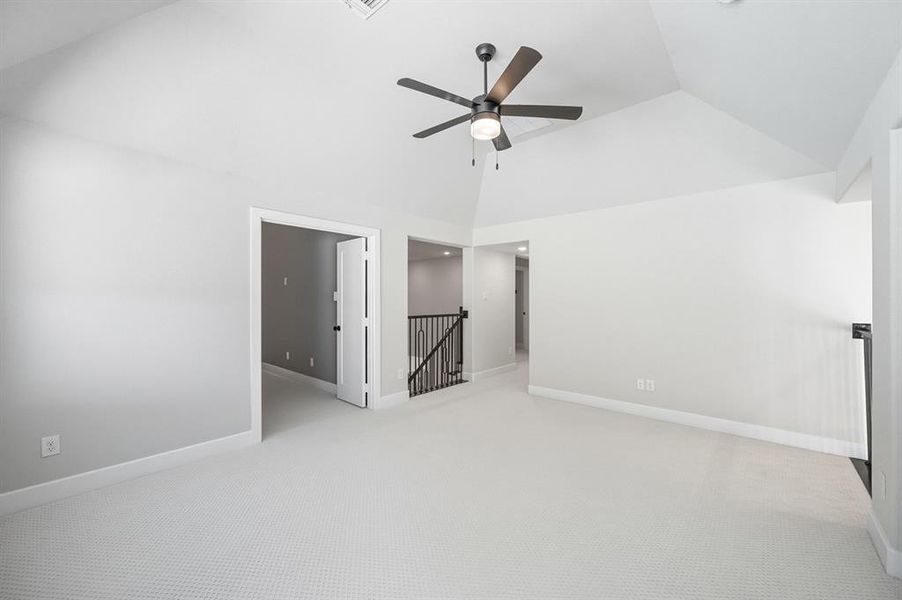 Unfurnished bedroom with carpet flooring, a ceiling fan, and high vaulted ceiling