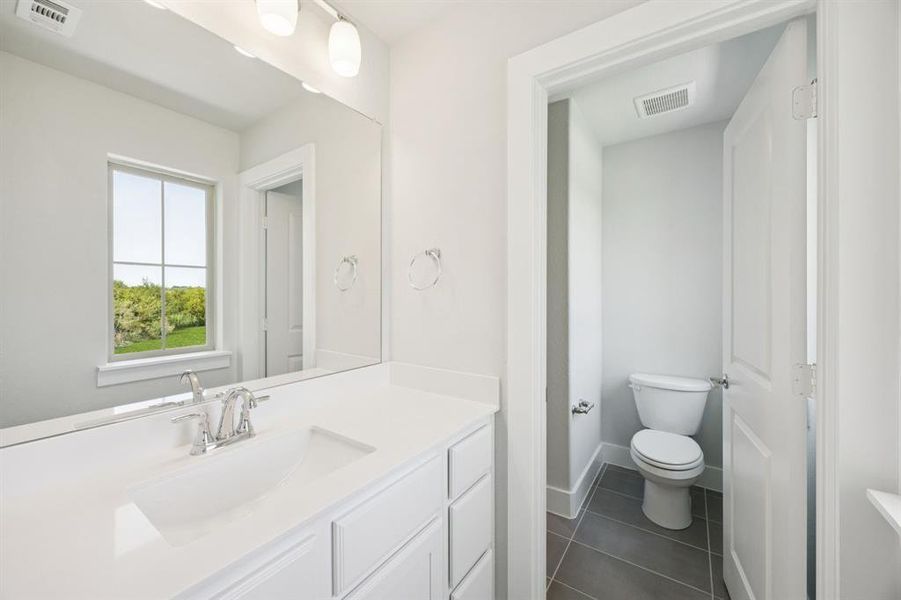Bathroom with vanity and dark tile patterned flooring