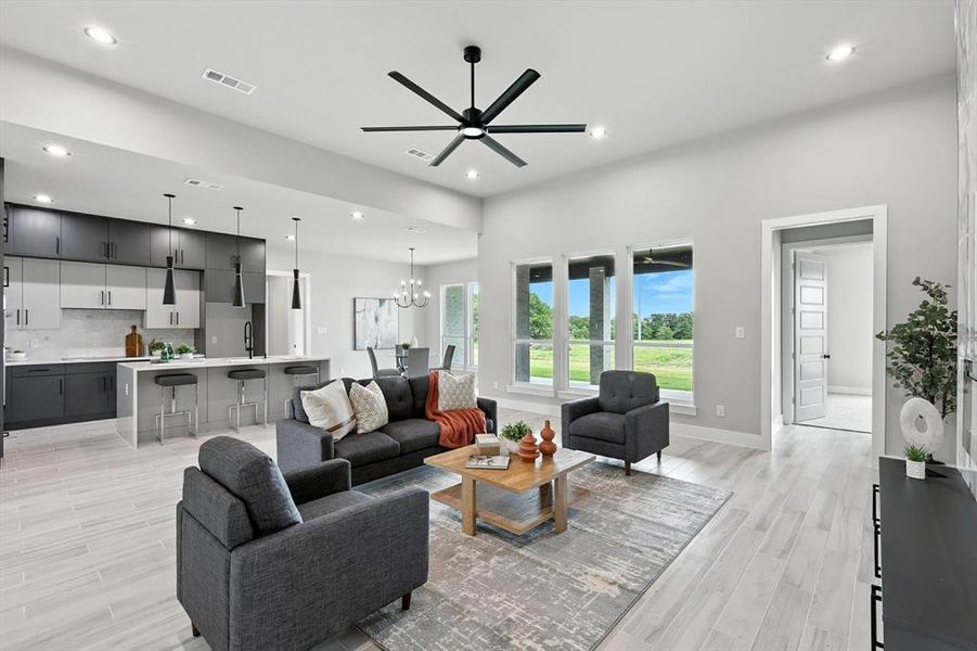 Living area featuring a ceiling fan, light wood-style floors, recessed lighting, and a chandelier Living area featuring a ceiling fan, light wood-style floors, recessed lighting, and a chandelier