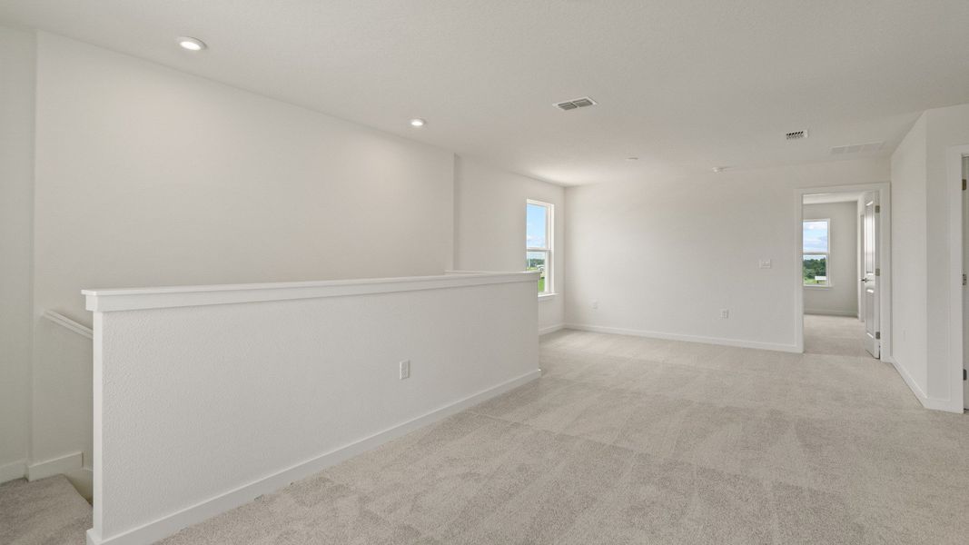 Bright and open upstairs landing connects living spaces, offering flexibility for a reading nook, desk, or lounge area