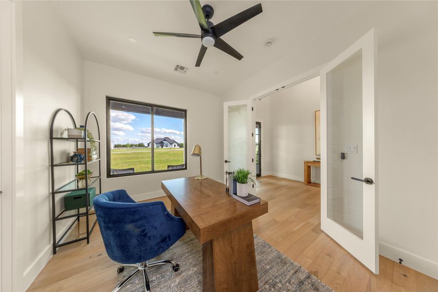 Home office featuring light wood-style flooring and ceiling fan