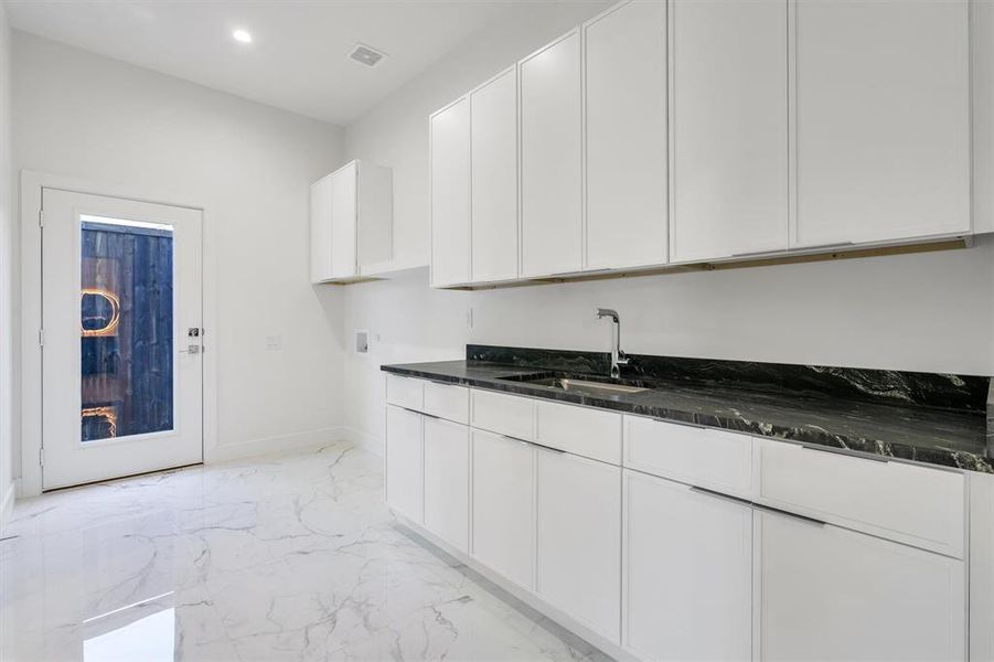 Kitchen with baseboards, recessed lighting, white cabinets, marble finish floor, and a sink