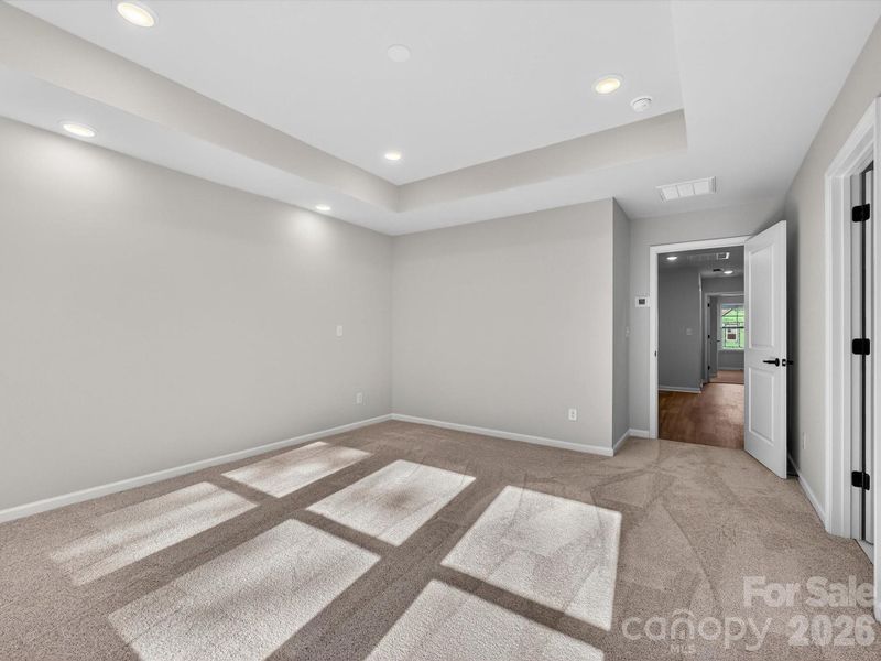 Primary bedroom features tray ceiling