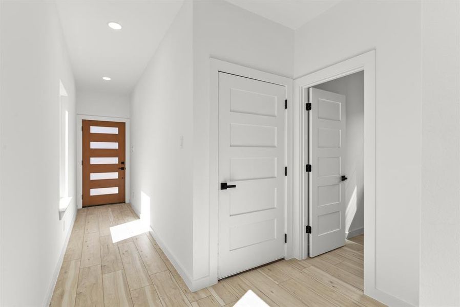 Corridor with light wood-style flooring, baseboards, and recessed lighting