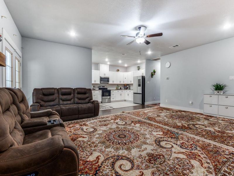 Living room featuring ceiling fan and light wood-style floors Living room featuring ceiling fan and light wood-style floors