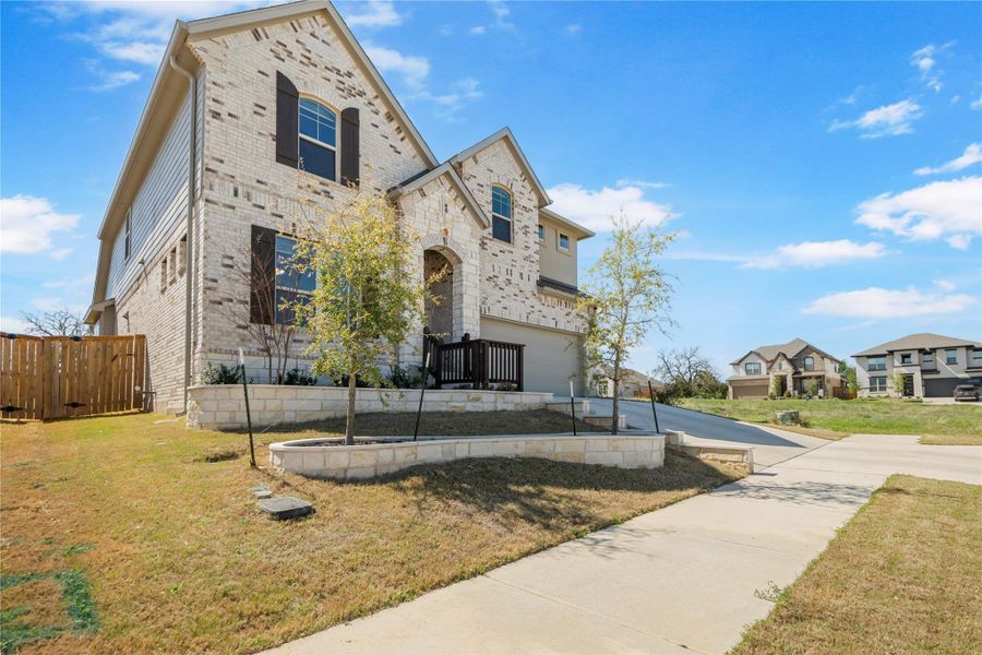 A graceful home features a brick and stone facade, charming shutters, and a well-kept lawn with established trees. A graceful home features a brick and stone facade, charming shutters, and a well-kept lawn with established trees.