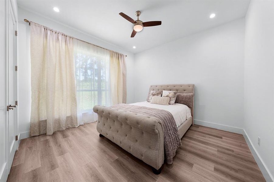 Bedroom featuring light wood finished floors, a ceiling fan, and recessed lighting Bedroom featuring light wood finished floors, a ceiling fan, and recessed lighting