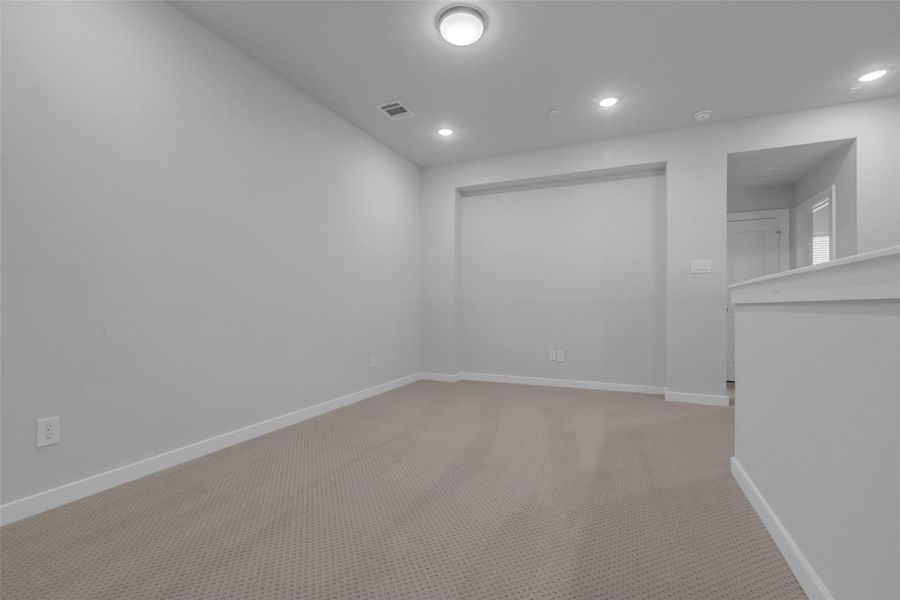 Upstairs loft area featuring a recessed accent wall.