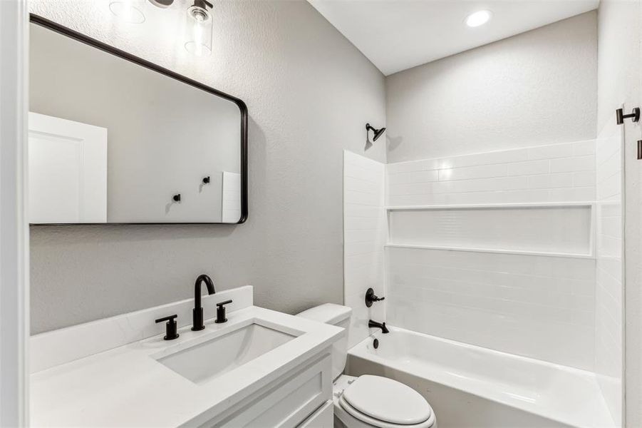 Full bathroom featuring vanity, toilet, and washtub / shower combination