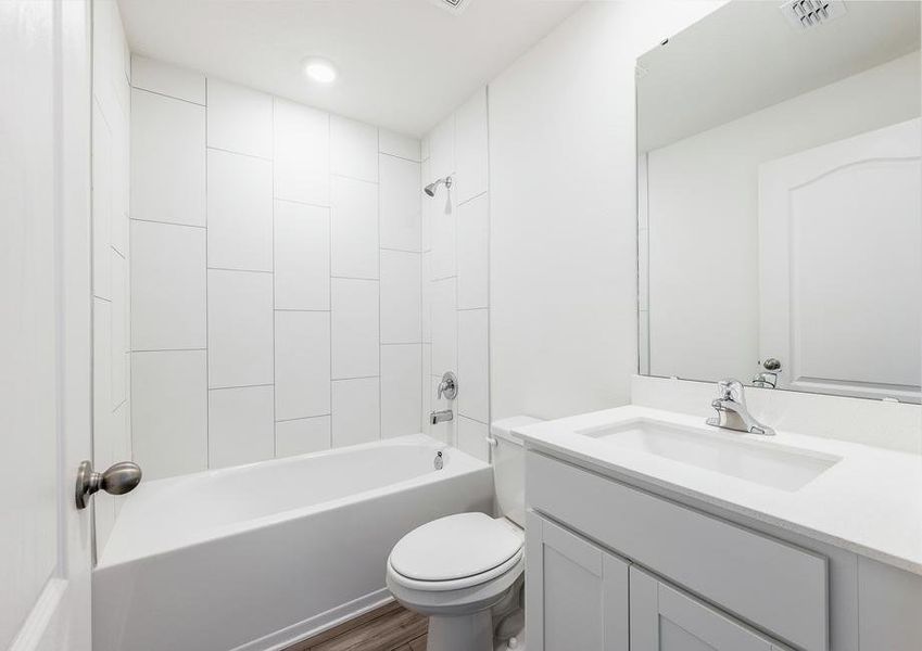 The guest bathroom has beautiful white tile detail.