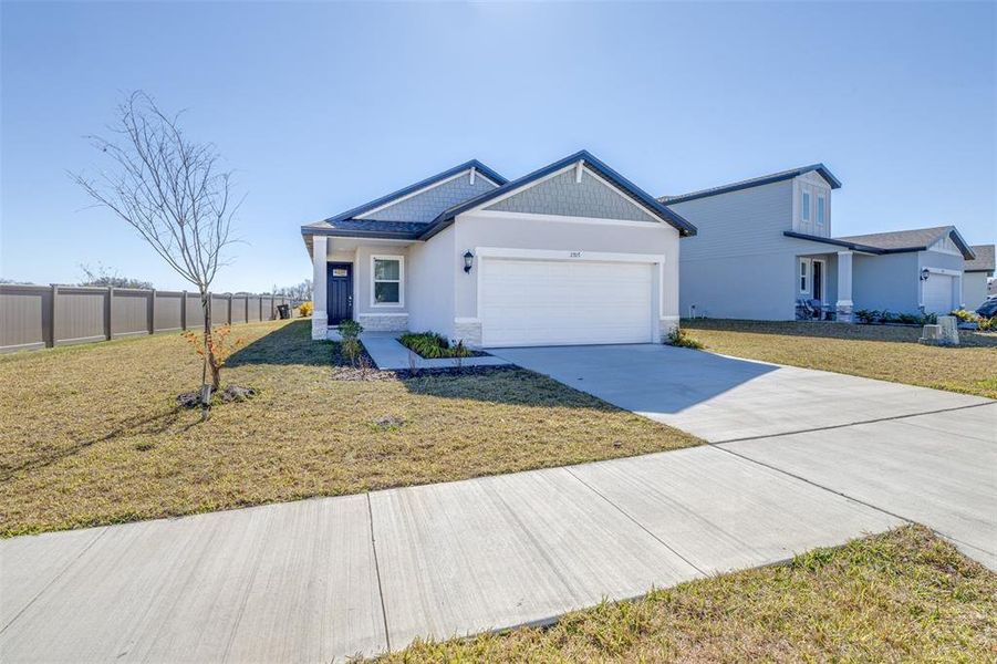 Front exterior of a new home in The Grove at Stuart Crossing - Premier Series, Bartow, FL, highlighting curb appeal (Image 19).
