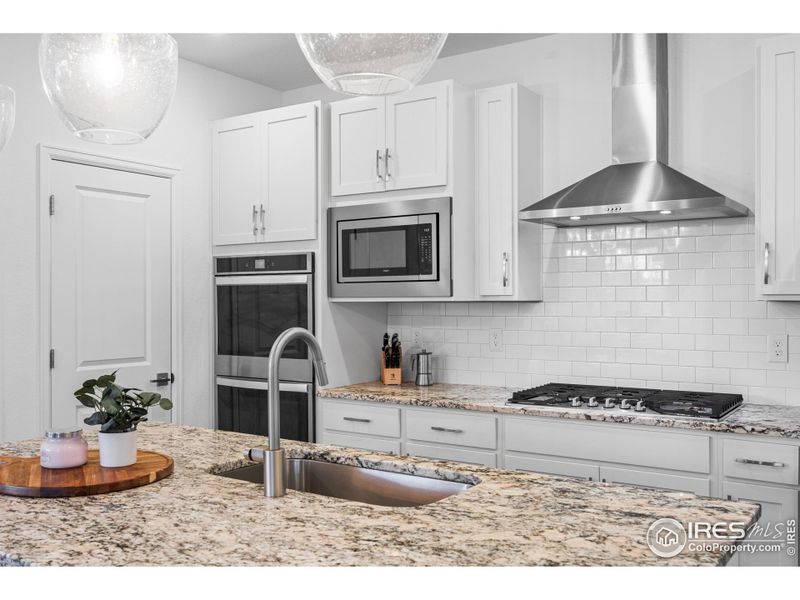 granite countertops, double oven, gas stovetop, and stainless steel appliances