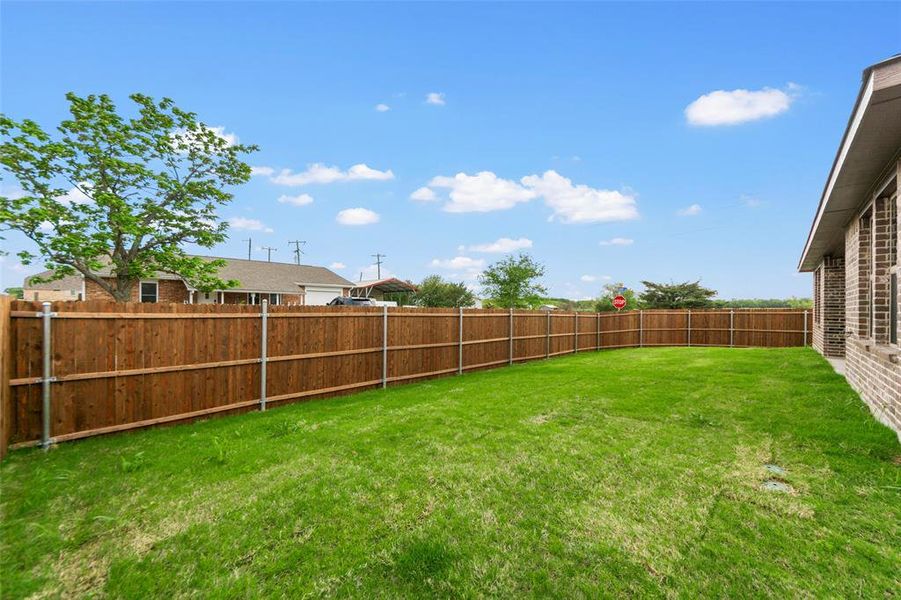 Expansive grassy yard with a complete wood privacy fence
