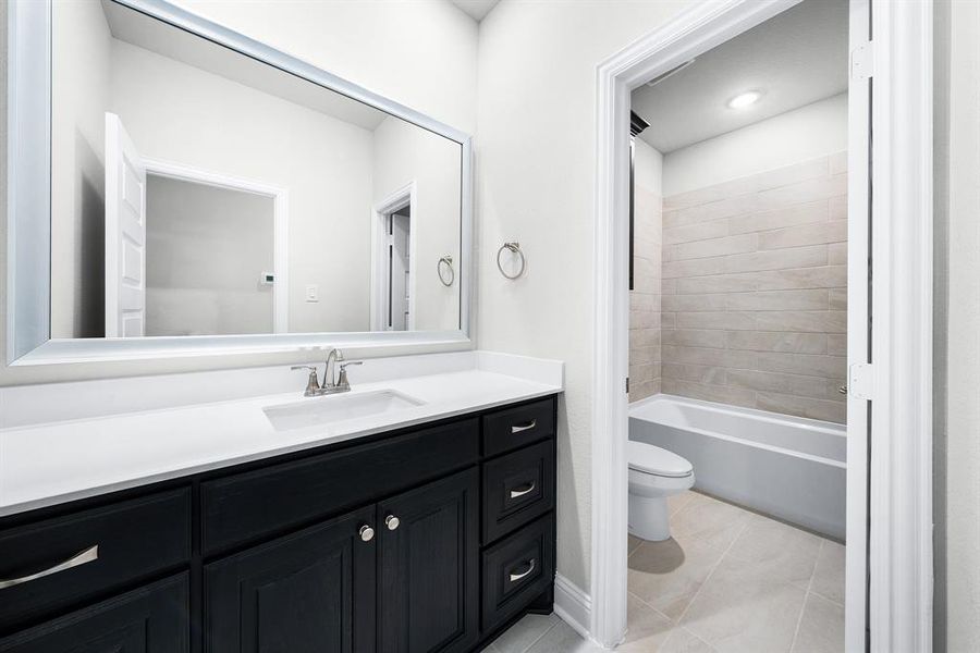 Bathroom featuring vanity, tile patterned flooring, and shower / bathtub combination Bathroom featuring vanity, tile patterned flooring, and shower / bathtub combination