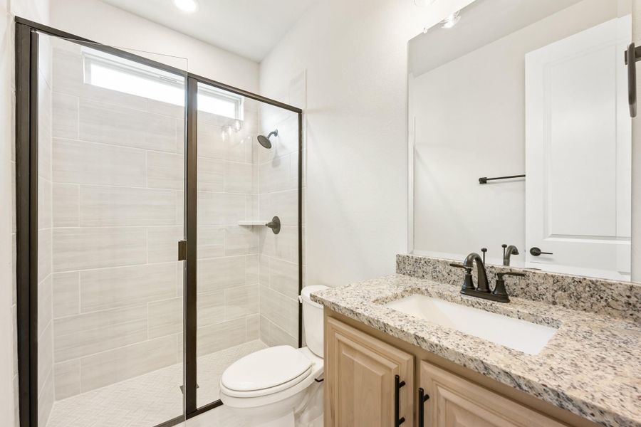 Bathroom with tiled walk-in shower, granite vanity countertop, and dark bronze fixtures Bathroom with tiled walk-in shower, granite vanity countertop, and dark bronze fixtures