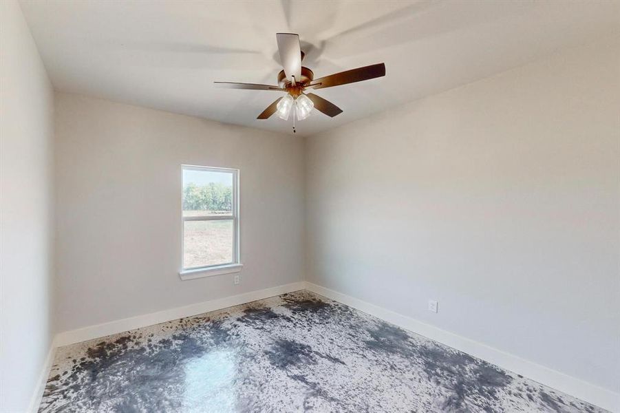 Unfurnished room with ceiling fan and concrete floors