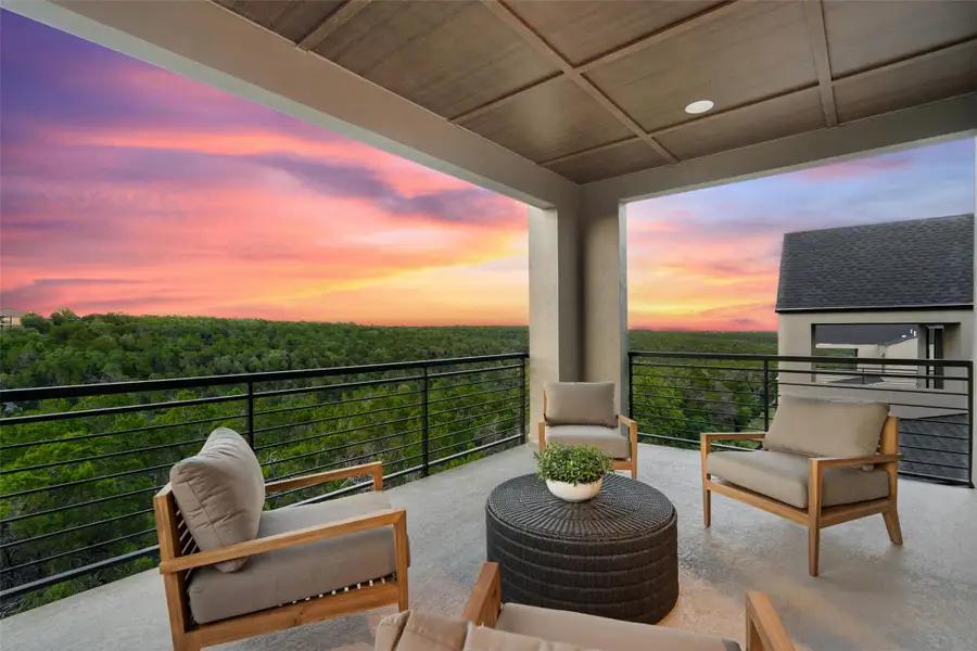 An inviting covered balcony offers panoramic forest views beneath a radiant sunset sky. An inviting covered balcony offers panoramic forest views beneath a radiant sunset sky.