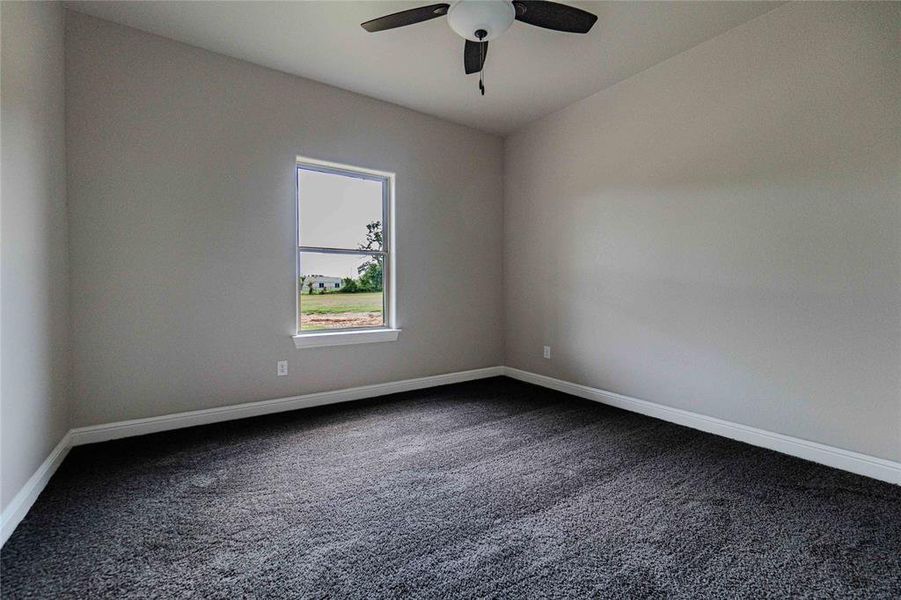 Empty room featuring carpet floors and ceiling fan