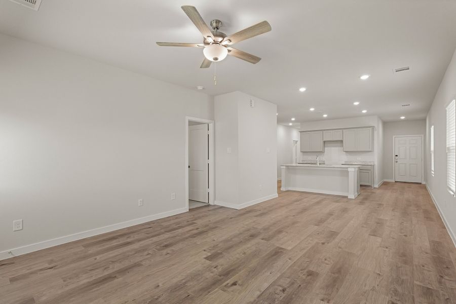A room with a wood floor and a ceiling fan. A room with a wood floor and a ceiling fan.