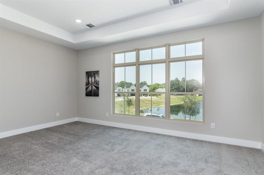 Primary bedroom with lots of natural lighting, and recessed light fixtures.