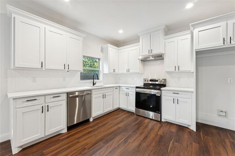Kitchen featuring appliances with stainless steel finishes, tasteful backsplash, white cabinets, and recessed lighting