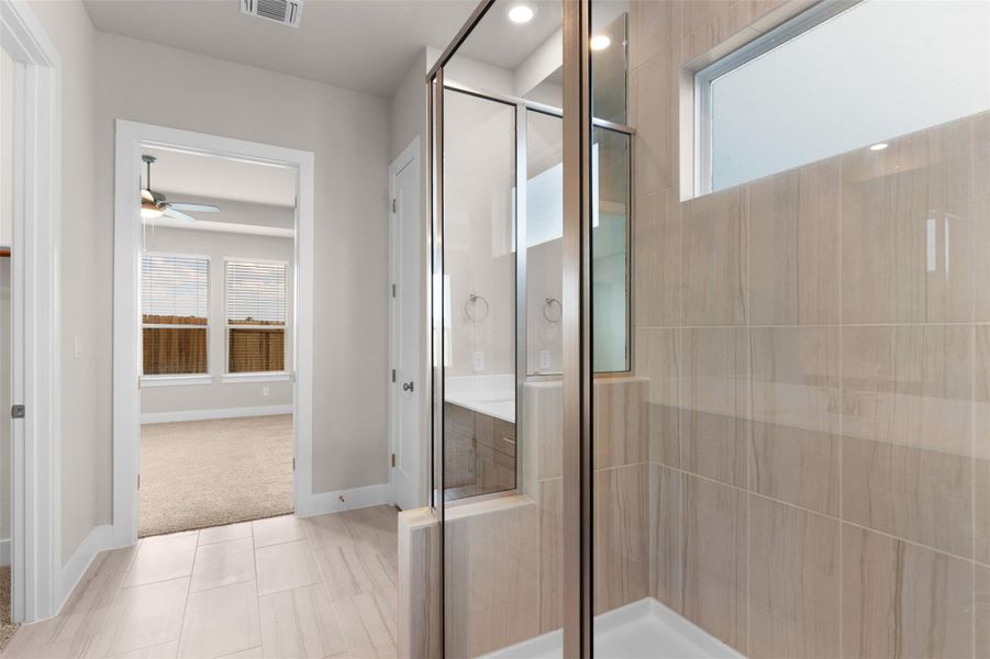 Bathroom featuring healthy amount of natural light, a shower stall, and tile patterned floors