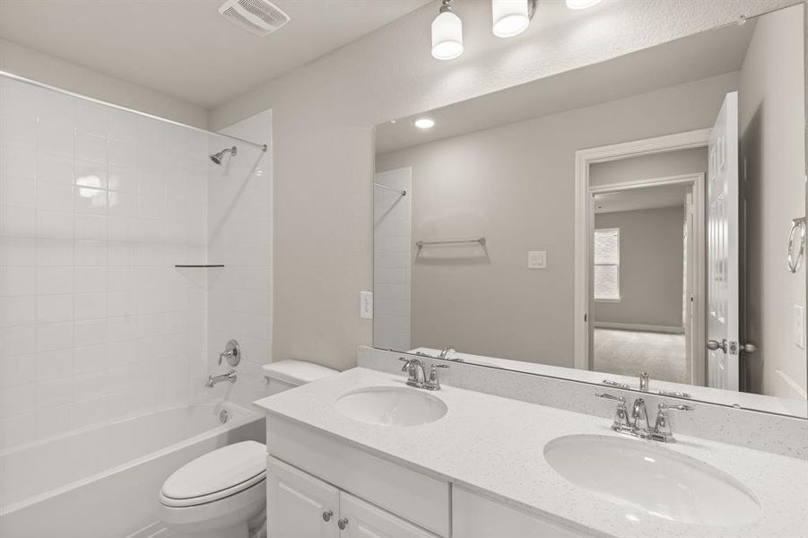 The secondary bath features tile flooring, white cabinetry and light countertops and a shower/tub combo. Perfect for accommodating any visiting family and friends.