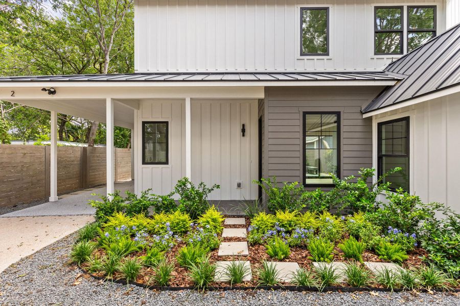 Doorway to property with board and batten siding, a standing seam roof, a metal roof, and an attached carport Doorway to property with board and batten siding, a standing seam roof, a metal roof, and an attached carport