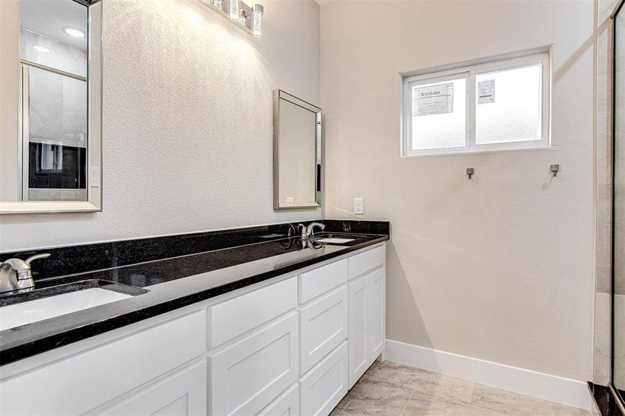 Bathroom featuring tile patterned flooring, vanity, and an enclosed shower