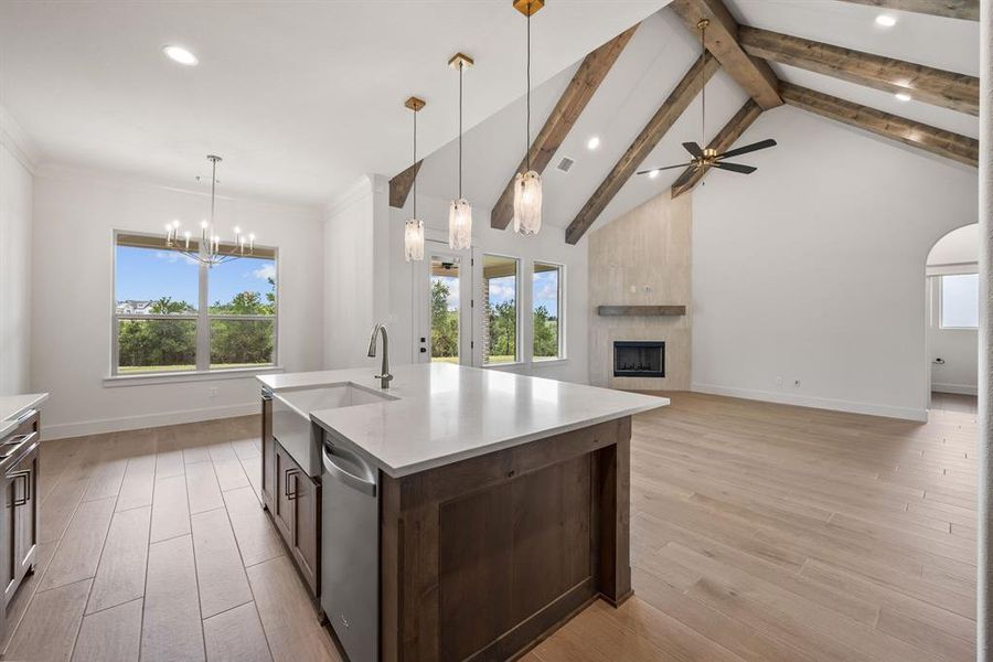 Spacious living area featuring an expansive kitchen island with a farmhouse sink, stainless steel appliances, and pendant lighting