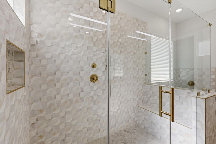 Yes, the shower is large enough for its very own bench seat! You won't find this gold trimmed tile anywhere else, and you'll love the rainfall showerhead and personal hand-held sprayer.