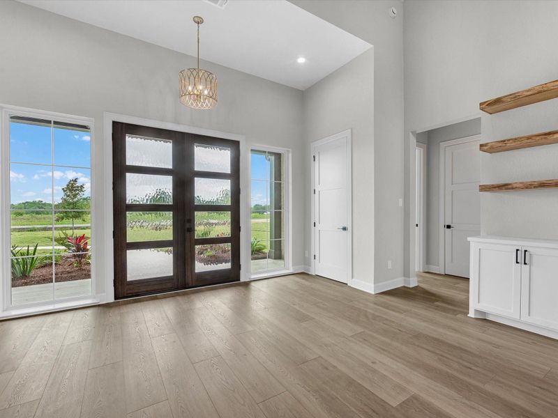 Grand front entry with double glass doors and soaring ceilings into the great room. Grand front entry with double glass doors and soaring ceilings into the great room.