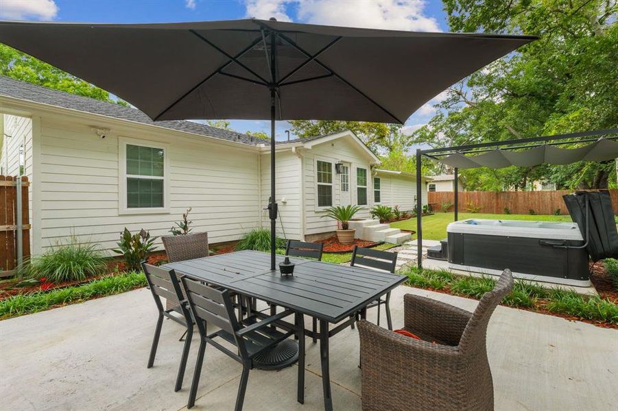 View of patio featuring a hot tub and outdoor dining space View of patio featuring a hot tub and outdoor dining space