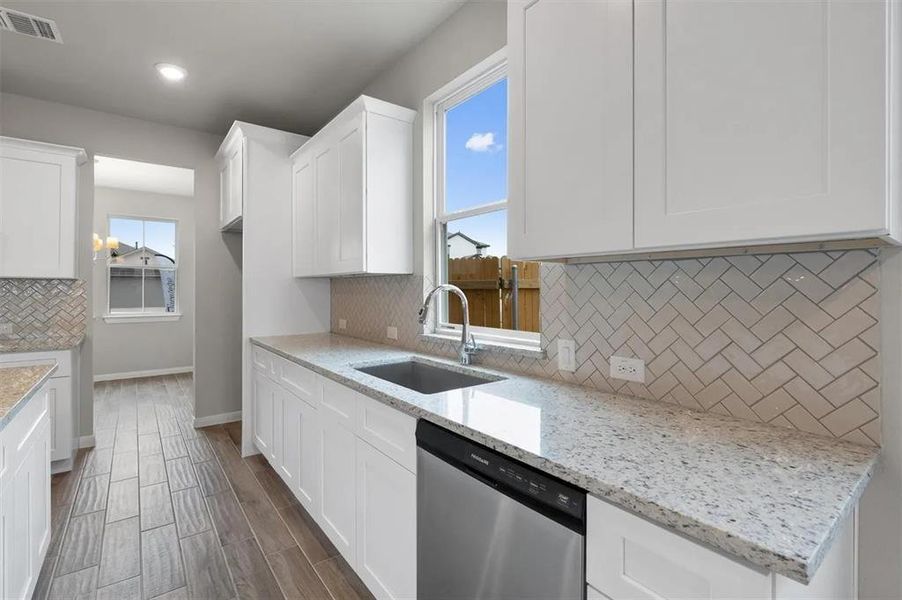 Bright white cabinetry and a patterned backsplash elevate this functional kitchen space.