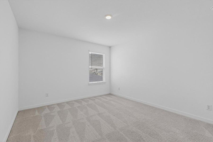 Spare room with light colored carpet and baseboards