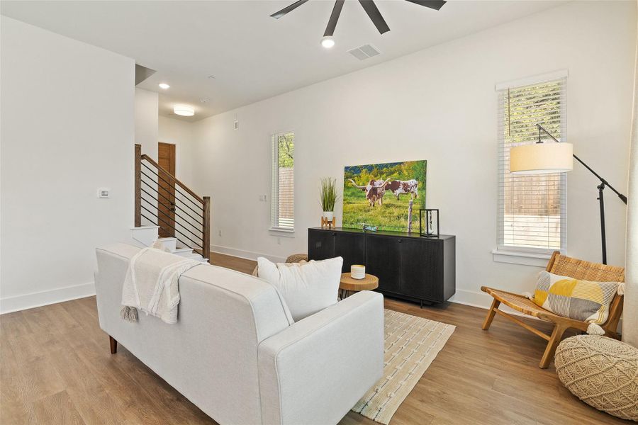 Living room featuring wood finished floors, recessed lighting, ceiling fan, and stairway Living room featuring wood finished floors, recessed lighting, ceiling fan, and stairway