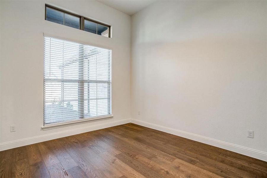 Large study with french doors featuring inlaid glass, ceiling fan and large window