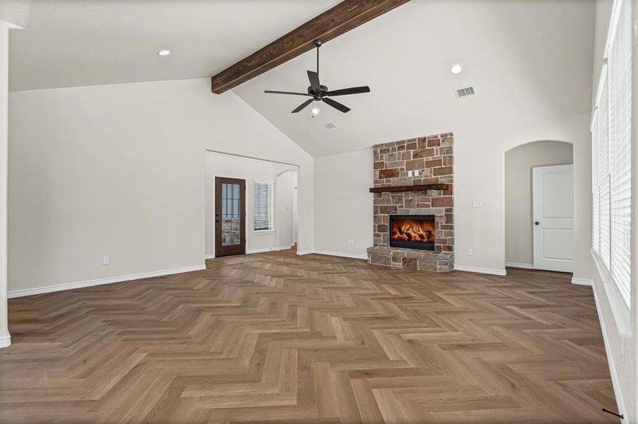 Unfurnished living room with a fireplace, high vaulted ceiling, a ceiling fan, beam ceiling, and recessed lighting