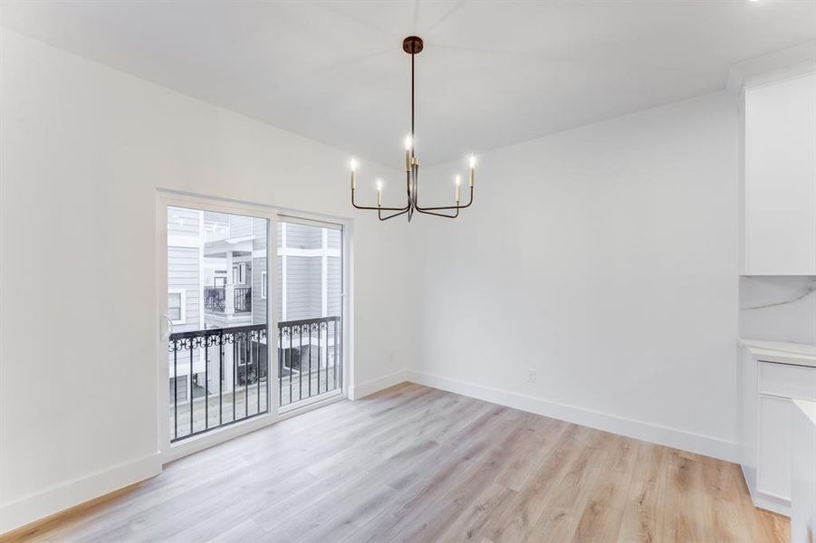 The dining area is open to the kitchen, living room. It has an elegant light fixture.