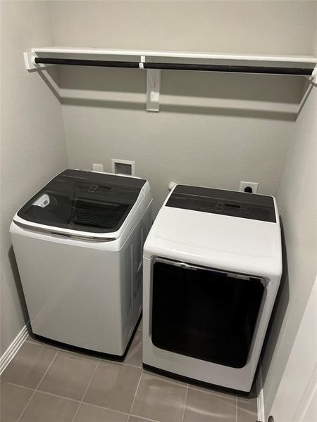 Laundry area with light tile patterned floors and washer and dryer