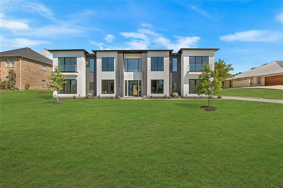 View of front of property with a garage and a front lawn